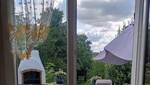 A patio area with a stone floor, a grill, and outdoor furniture. - L'Orchidée - Two Bedroom House, Sleeps 6 (Limerzel)