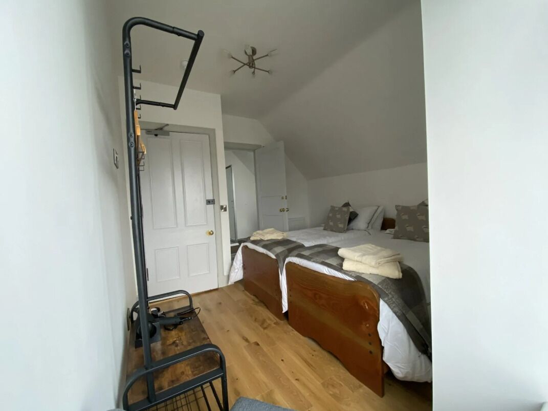 Un dormitorio con cama, escritorio y ventilador de techo.