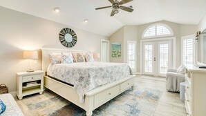 A bedroom with a bed, nightstand, dresser, and a ceiling fan. - Spacious Beachside Home w/ Long Gulf View, Covered Deck & Huge Primary Suite (Galveston)