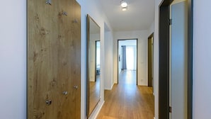 Ein Flur mit Holztüren, einer Leuchte und Blick in einen anderen Raum.
