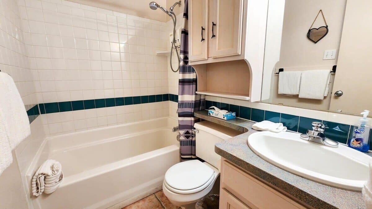 A bathroom with a bathtub, toilet, sink, and a towel rack.