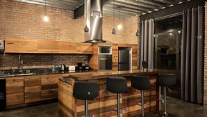 A modern kitchen with a wooden island, stainless steel appliances, and bar stools. - Luxury Stays (Tlacopac, Álvaro Obregón)