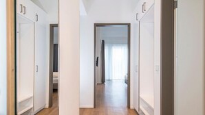 A hallway with white wardrobes and a wooden floor.