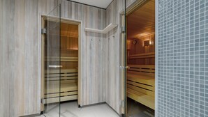 A modern bathroom with wooden paneling, a glass shower enclosure, and a tiled wall.