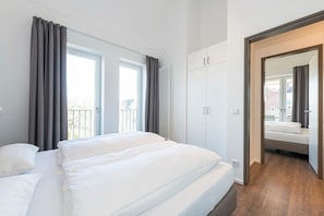 Un dormitorio moderno con una cama grande, un armario y vistas al exterior.