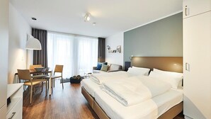 Quarto de hotel moderno com uma cama grande, uma escrivaninha e uma cadeira.
