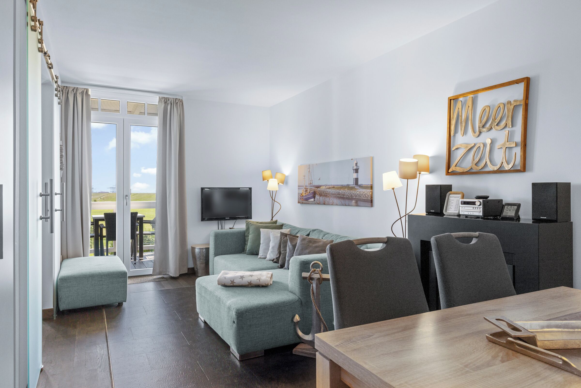 Ein modernes Wohnzimmer mit einer Couch, einem Esstisch und einem Fernseher.