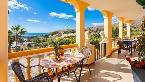 A balcony with a table and chairs, overlooking a scenic landscape with a view of the sea and hills. - Villa Las Palomas - Three Bedroom Villa, Sleeps 6 (Frigiliana)