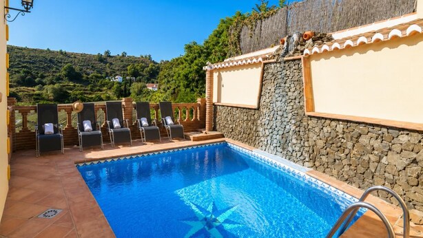 A swimming pool with a star-shaped design, surrounded by lounge chairs and a stone wall. - Villa Las Palomas 2 - Three Bedroom Villa, Sleeps 5 (Frigiliana)