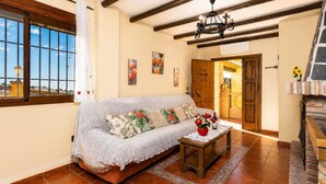 A cozy living room with a sofa, a coffee table, and a fireplace. - Villa Las Palomas 2 - Three Bedroom Villa, Sleeps 5 (Frigiliana)