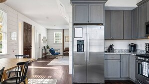 A modern kitchen with grey cabinets, a stainless steel refrigerator, and a built-in oven. - Historic Charleston Single w/ Private Outdoor Space (Charleston)
