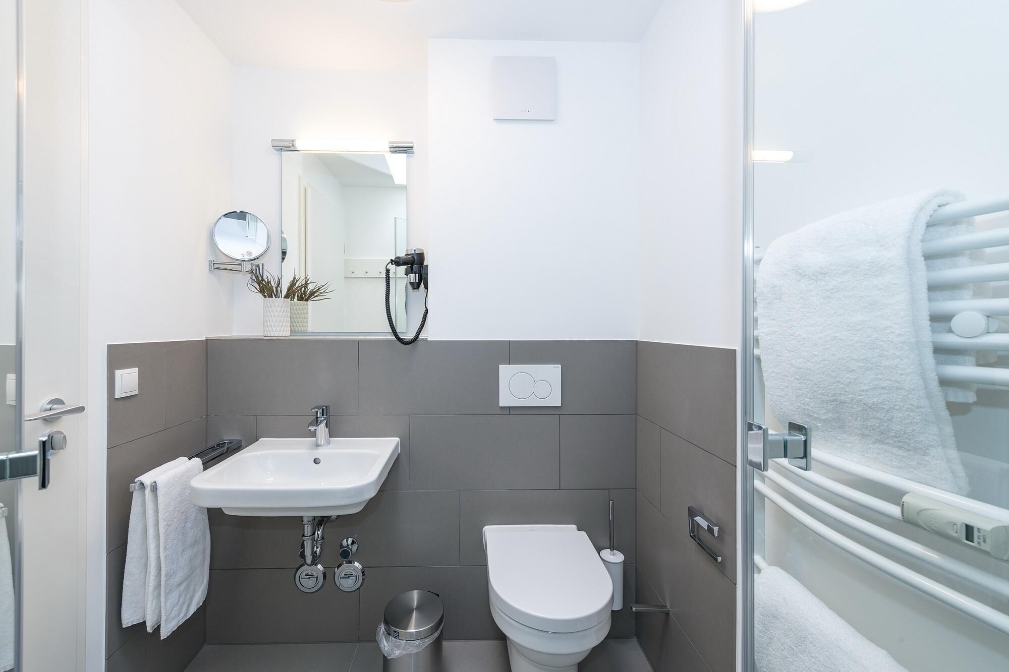 Ein modernes Badezimmer mit Waschbecken, Toilette und Duschbereich.