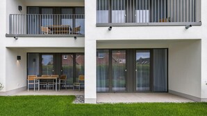 A two-story residential building with a balcony and a patio area.