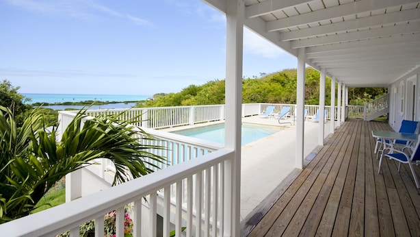 A covered outdoor area with a pool, wooden deck, and white railings. - Calabash 4 Bedroom Villa - Stunning Sea Views, Private Pool, Delightful Location (Darkwood Valley)
