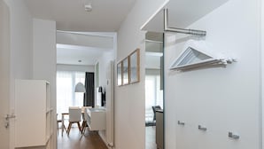 Una habitación de hotel moderna con comedor, un espejo grande y un radiador.
