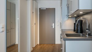 A modern kitchen with a stainless steel sink, a built-in oven, and a microwave.