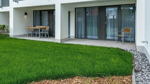 A modern building with a flat roof, large windows, and a well-maintained lawn. - Apartment nah der See mit Großer Terrasse, Parkplatz, Schwimmbad- & Saunanutzung (Nordseeheilbad Bensersiel)