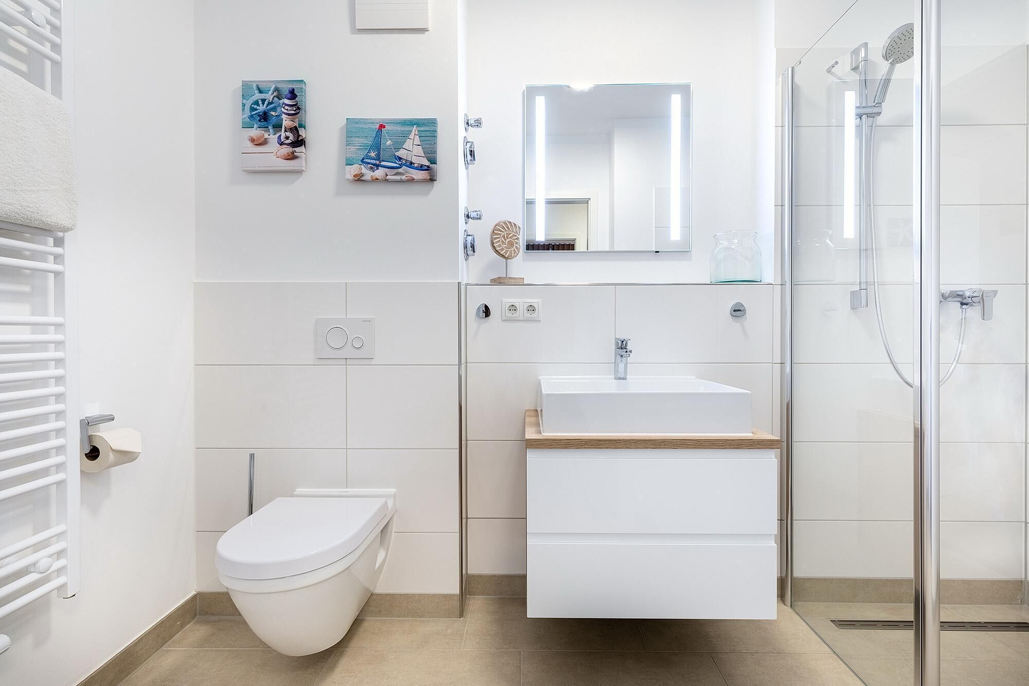 A modern bathroom with a toilet, sink, and shower.