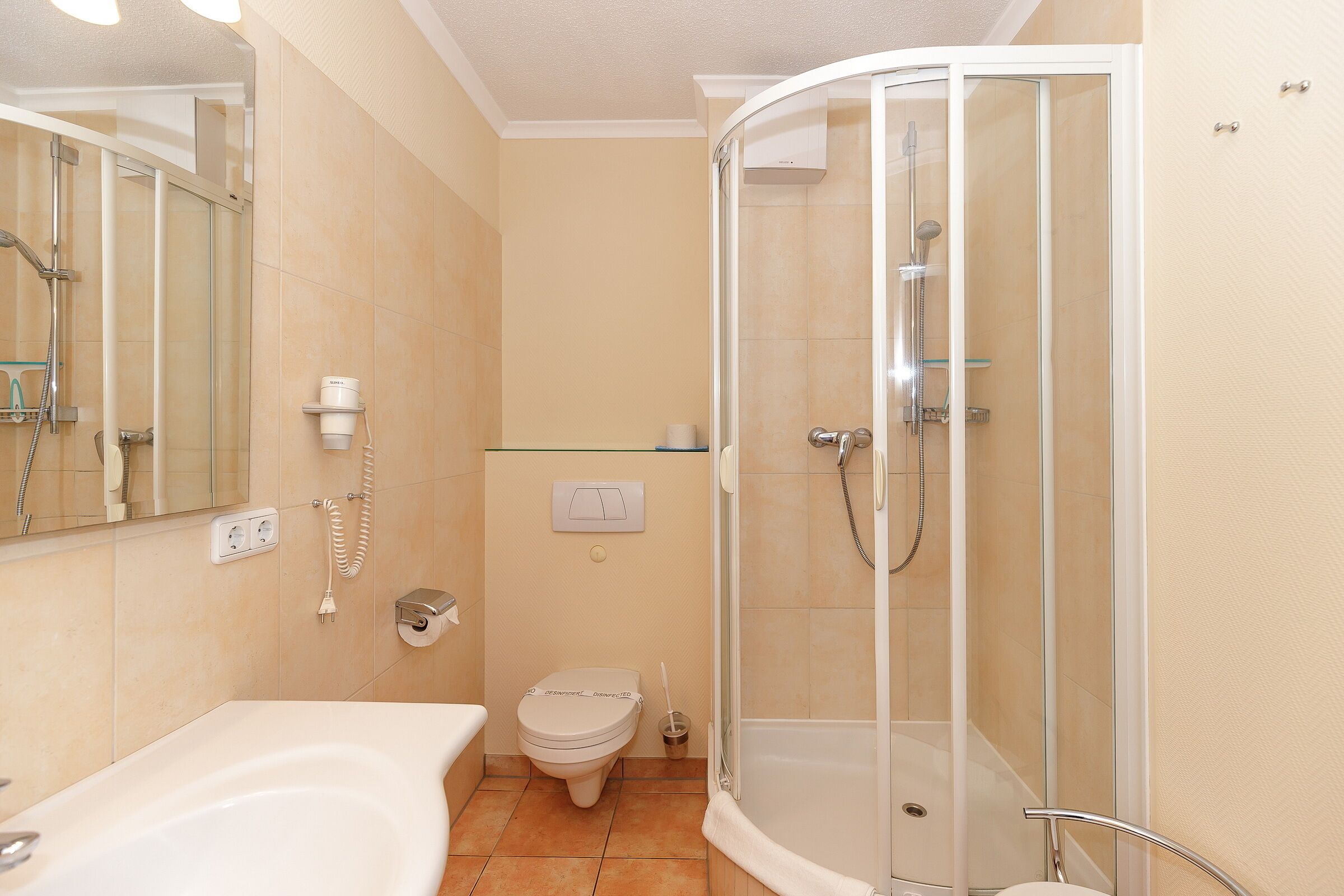 A bathroom with a bathtub, toilet, and a glass-enclosed shower stall.