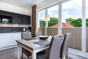Una cocina moderna con comedor, ventanas amplias y vistas a zonas verdes.