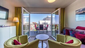A modern hotel room with a balcony, a round table, and two armchairs. - Great apartment with infrared sauna and balcony with a wonderful panoramic view! (Nordseeheilbad Schillig)
