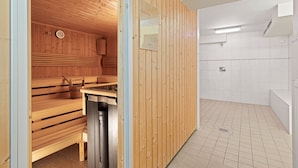 Ein Saunaraum mit Holzbänken und einer Holzwand.