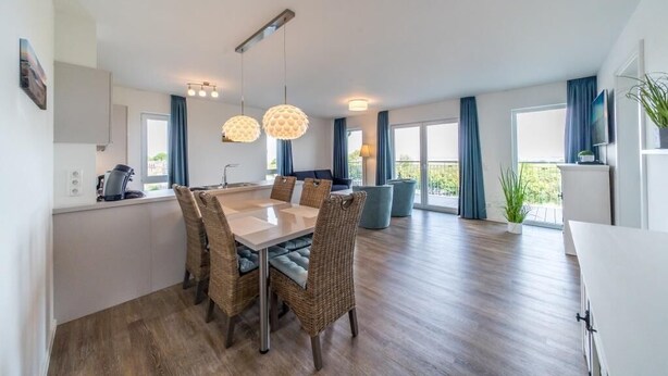 Una cocina moderna con zona de comedor, ventanas amplias y balcón.