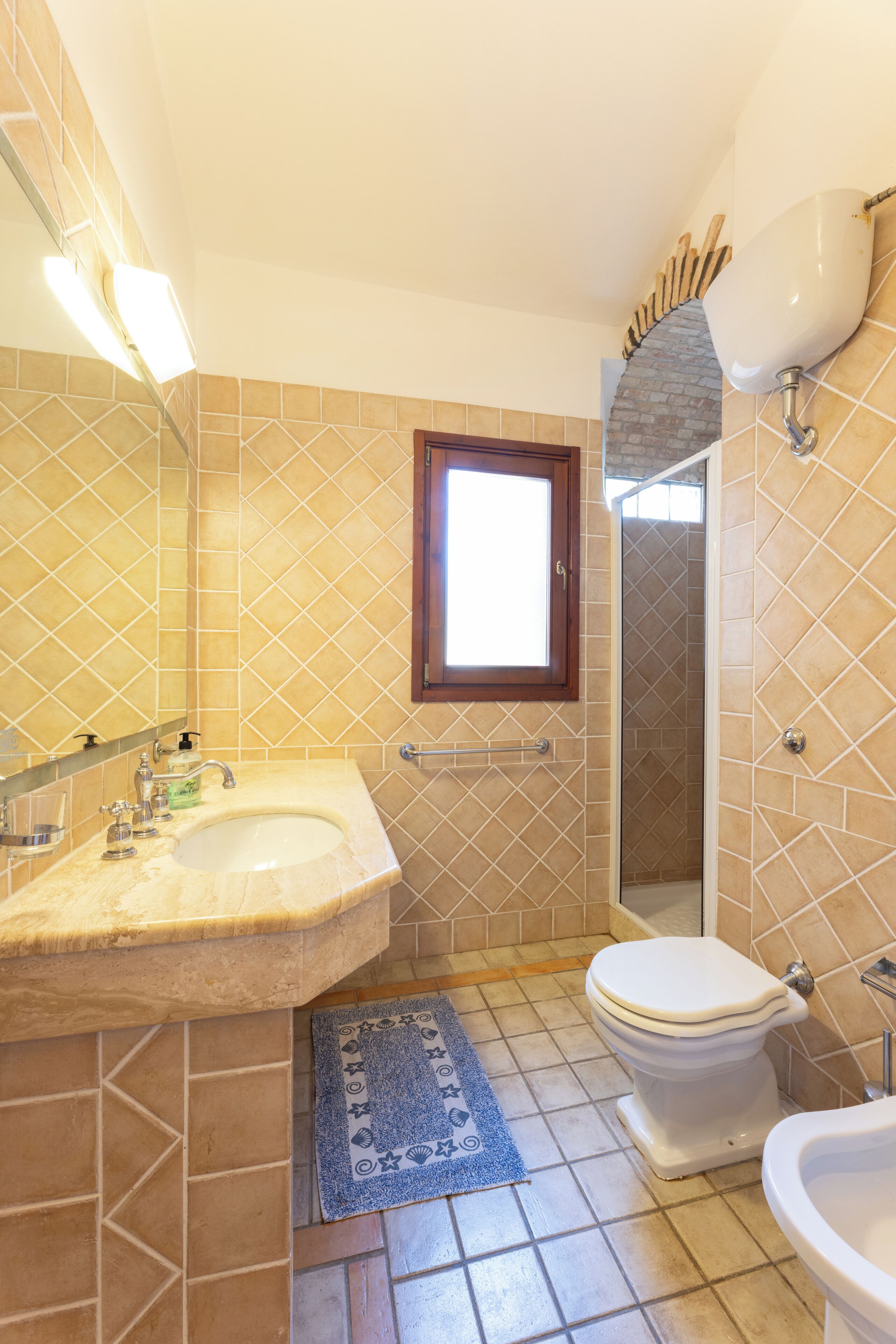 A bathroom with a sink, toilet, and shower.