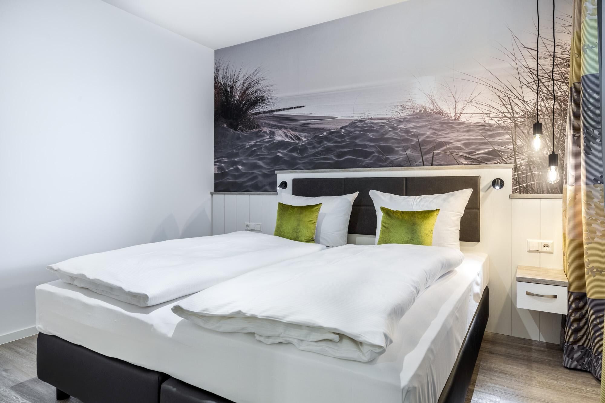 A modern bedroom with a bed, a headboard, a nightstand, and a wall-mounted artwork.
