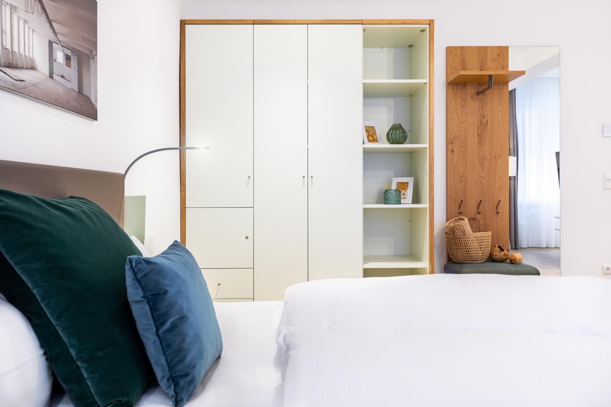 A bedroom with a bed, a wardrobe, and a nightstand.