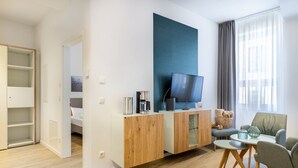 Un salon moderne avec un meuble en bois, un téléviseur à écran plat, un canapé et une table basse.