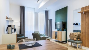 Een moderne woonkamer met een houten eettafel, een bank en een televisie op een houten kast.