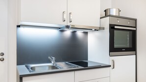 Een moderne keuken met roestvrijstalen apparatuur, een inbouwoven en een spoelbak.