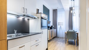 Una cocina moderna con electrodomésticos de acero inoxidable, un comedor con mesa y sillas, y una lámpara.