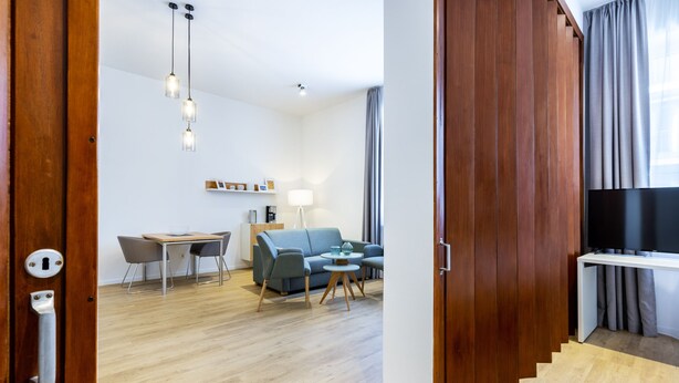 Una sala de estar moderna con un sofá, una mesa de centro y una zona de comedor.