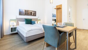 A modern hotel room with a bed, bedside tables, a desk, and a chair. - Modernes, Hundefreundliches Apartment in Außergewöhnlicher Hafenlage von Wismar (Hansestadt Wismar)