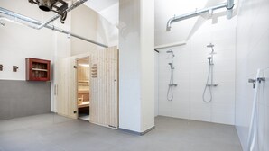 Un baño moderno con ducha, un armario de madera y suelo de baldosas.