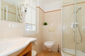 Un baño con bañera, inodoro y cabina de ducha con paredes de vidrio.
