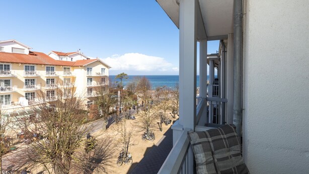 A balcony with a view of a beach and buildings.