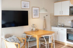 A modern kitchen with white cabinets, a built-in oven, and a sink.