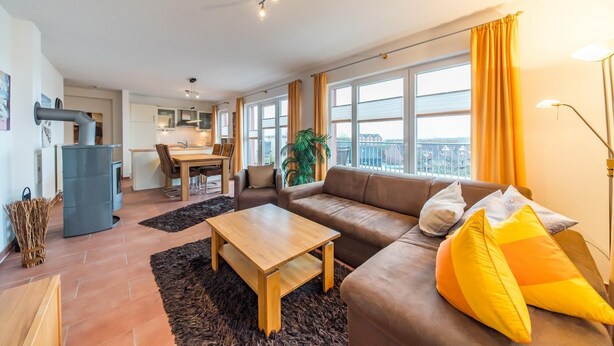 A modern apartment with a living room, dining area, and kitchen.