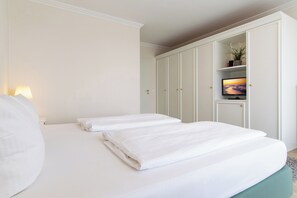 Una habitación de hotel con cama, televisión y armario.