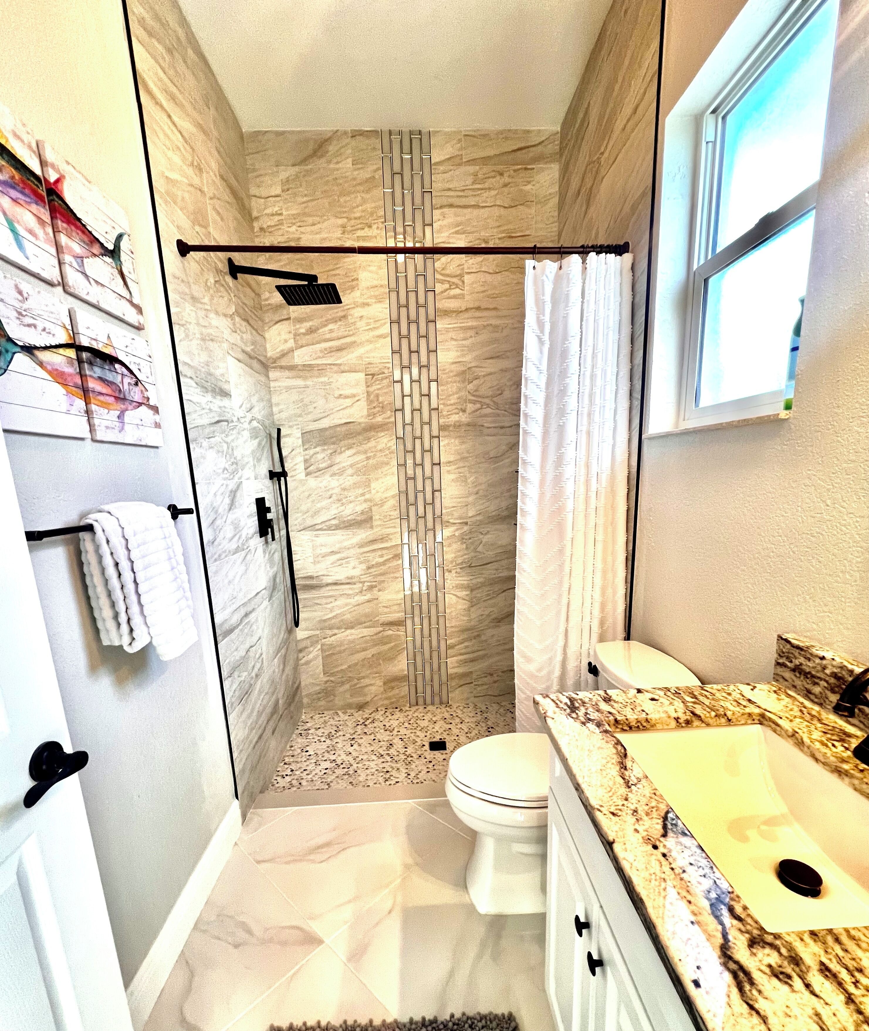 Une salle de bain avec une douche, des toilettes et un lavabo.