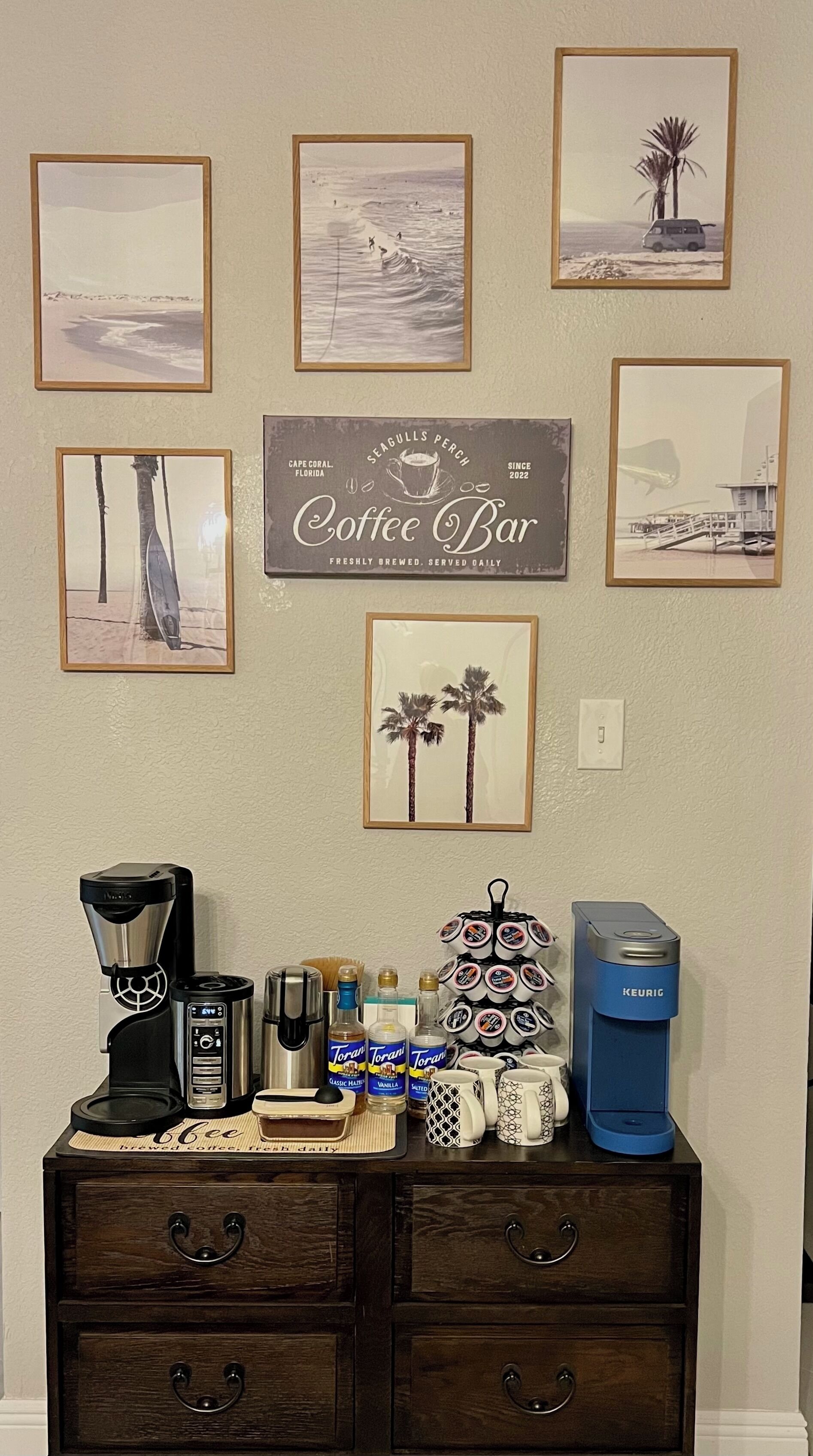 Disposición de una barra de café con una cafetera, tazas y siropes Torani.