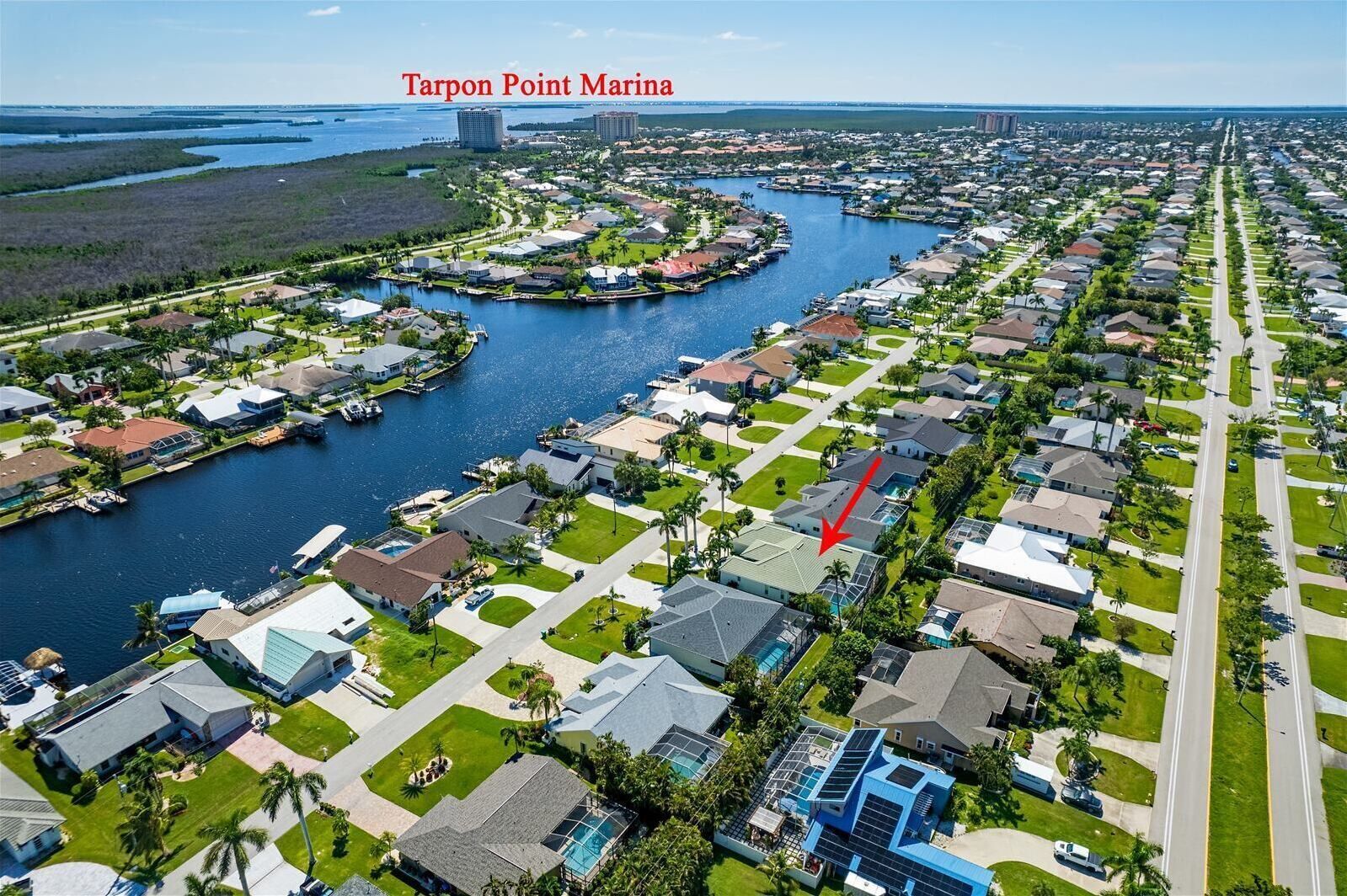 An aerial view of Tarpon Point Marina with residential areas, water bodies, and a marina.