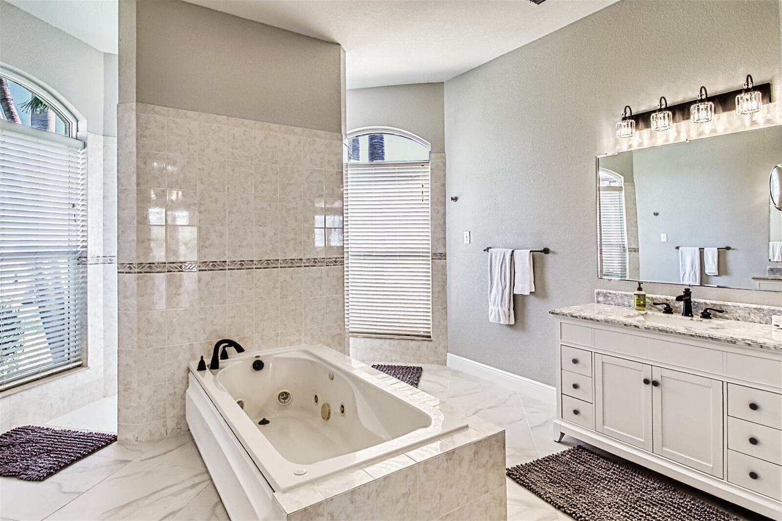 A modern bathroom with a freestanding bathtub, a large vanity with a mirror, and a shower area with a glass door.