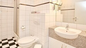 A bathroom with a toilet, sink, and shower.