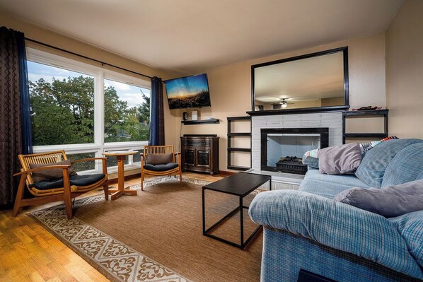 A living room with a fireplace, a television, and a sofa.