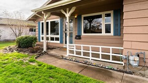 A residential house with a front porch, a mailbox, and a small garden area. - Comfortable Pet friendly (Albany)