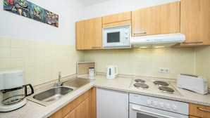 Una cocina equipada con microondas, tostadora, cafetera, lavaplatos y estufa.